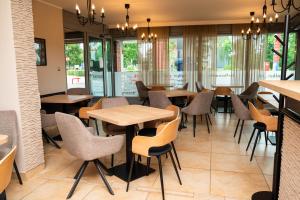 a restaurant with tables and chairs and windows at MOTEL MO&JA in Leszno