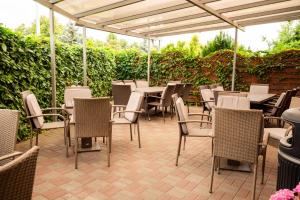 a patio with tables and chairs under an umbrella at MOTEL MO&JA in Leszno