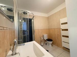 a bathroom with a tub and a toilet in it at Appartement La Jungle in Villebois