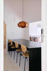 a dining room with a black table and chairs at Casa Montelongo - Adults Only in La Oliva