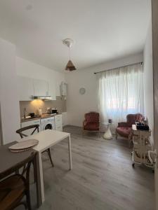 a living room with a table and a kitchen at AuraHouse in Mignanego
