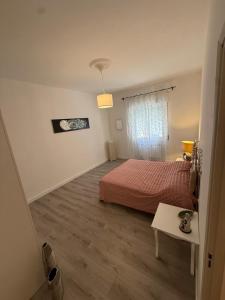 a bedroom with a bed and a table and a window at AuraHouse in Mignanego