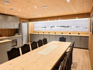 a conference room with a table and chairs and a large screen at Karstenstua in Holo