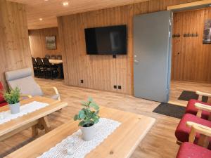 a living room with a table and a flat screen tv at Karstenstua in Holo
