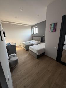 a bedroom with two beds and a desk and a chair at Lighthouse Hotel in Gyumri