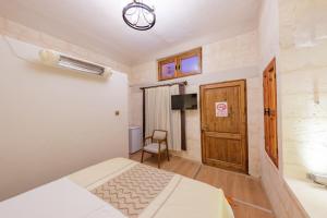 a bedroom with a bed and a chair and a door at Old Town Urfa in Urfa
