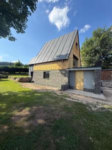 a large brick barn with a garage in a yard at Chalet Galla in Horní Blatná