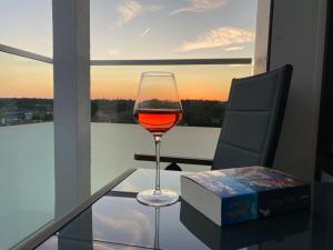 a glass of wine sitting on a glass table in front of a window at Ferienwohnung Ostseeverliebt 1-6-1 in Kellenhusen