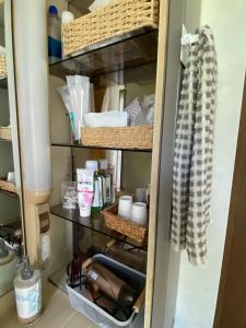 a kitchen pantry with baskets and dishes at Beach House Bellissima ! in Yomitan +27 photos