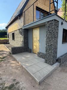 a house with a yellow door on the side of it at Chalet Galla in Horní Blatná