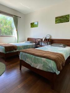 a bedroom with two beds and a window at Beach House Bellissima ! in Yomitan