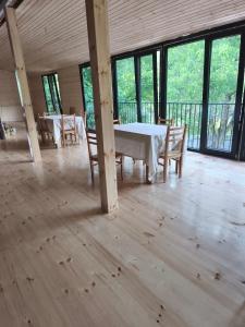 a dining room with a table and chairs and windows at guest house udziro in Oni