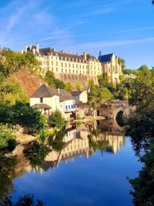 a large building on a hill next to a river at THOUARS Rivière LODGE KAËLI in Maulais