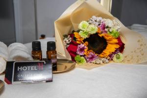 a bouquet of flowers and two bottles of honey at Hotel H Galería Club in Tuxtla Gutiérrez