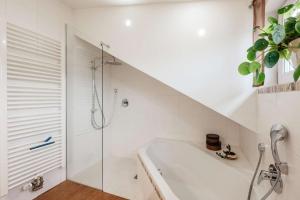a white bathroom with a tub and a shower at Haus Heidi in Freyung