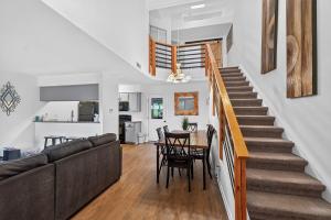 a living room with a staircase and a table and chairs at Birdies & Bikes at Fairway 45 in Bella Vista