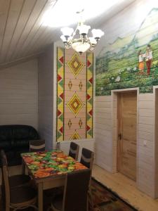 a dining room with a table and a mural at Hammam Spa Villa DAROSO in Kosiv