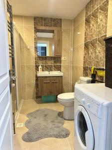 a bathroom with a washing machine and a toilet at Arden home in Van