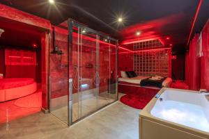 a red bathroom with a tub and a bedroom at L'Interdit, Confort et Sensualité in La Ferté-Gaucher +32 photos