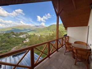 a balcony with a table and chairs and mountains at Mountain Symphony House Dilijan in Dilijan