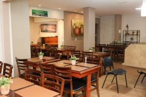a dining room with wooden tables and chairs at Hotel Rezende in Lambari +68 photos