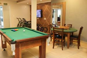 a living room with a pool table and chairs at Hotel Rezende in Lambari