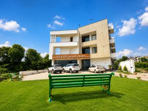 a green park bench in front of a building at The hotel golden crown in Baddi