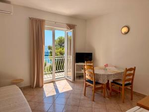 a living room with a table and chairs and a television at Apartments Mustel Drage - Adults Only in Drage