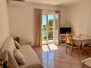 a living room with a couch and a table and a television at Apartments Mustel Drage - Adults Only in Drage