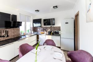a kitchen with purple chairs and a table in a kitchen at Aquamarine House in Tivat