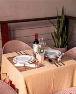 a table with a bottle of wine and plates on it at Pousada Manhã Dourada in Morro de São Paulo +31 photos