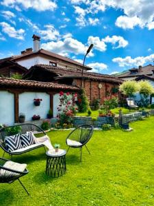 a yard with chairs and a house in the background at Арбория in Koprivshtitsa