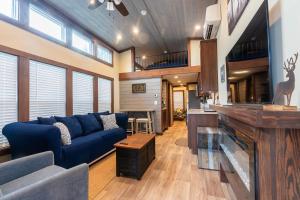 a living room with a blue couch and a table at Deers Den River- Luxury Tiny Home on River in Bryson City