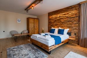 a bedroom with a bed and a wooden wall at Арбория in Koprivshtitsa