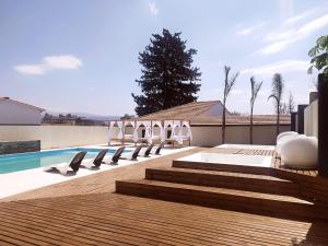 a group of chairs sitting on a deck next to a swimming pool at Hotel Astoria in Villa Carlos Paz