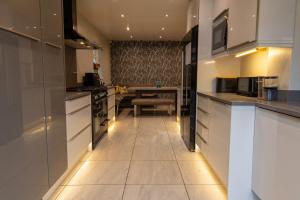 a kitchen with white cabinets and a table at Sundale House in Lurgan