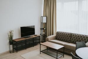 a living room with a couch and a flat screen tv at Hotel Central Vlašić in Vlasic