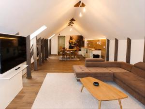 a living room with a couch and a tv at Generalis Wine Hotel in Tokaj