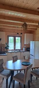 a kitchen with a wooden table and chairs in a kitchen at Dom na wyłączność U Eskulapa in Lutowiska