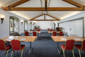 a conference room with wooden tables and red chairs at Wysses Rössli in Schwyz