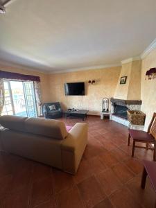 a living room with a couch and a fireplace at Quinta Do Ribeirinho in Vilar da Mó