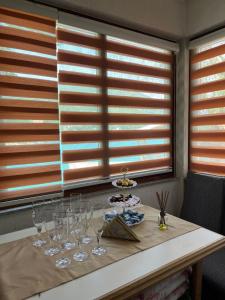 a table with wine glasses on it with a window at Vikendica Jablaničko jezero in Jablanica