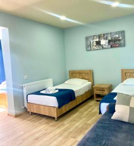 Zwei Betten in einem Zimmer mit blauen Wänden und Holzböden in der Unterkunft жули in Gonio