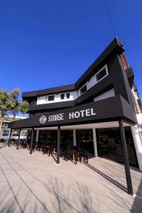 a store front of a hotel with tables and chairs at Hotel Storge in Villa Carlos Paz
