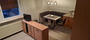 a living room with a table and a small table with a television at Haus Haase in Prenzlau