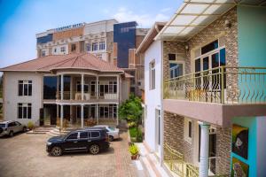 a car parked in a parking lot between two buildings at COMFORT HOTEL Ltd in Gasanze