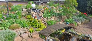 a garden with a bridge over a pond and flowers at Haus Haase in Prenzlau +9 photos