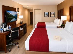 a hotel room with two beds and a desk at Comfort Inn in Saint-Georges +34 photos
