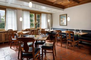 a dining room with tables and chairs and windows at Wysses Rössli in Schwyz +19 photos