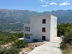 a white building on the side of a mountain at Maginja house in Milojci